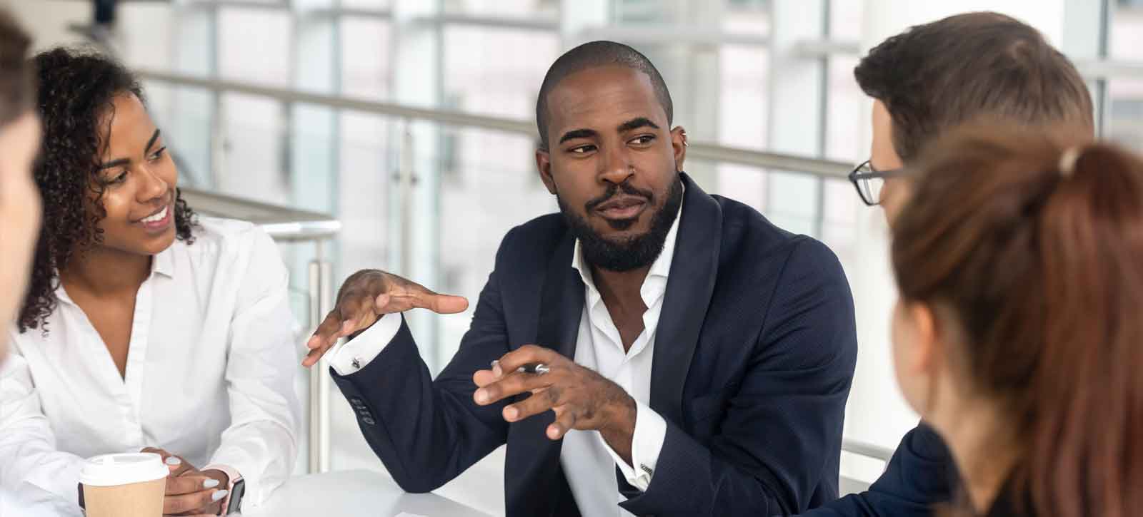 Man talking with classmates or coworkers at table