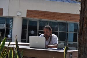 AULA student sitting at outside table working on laptop