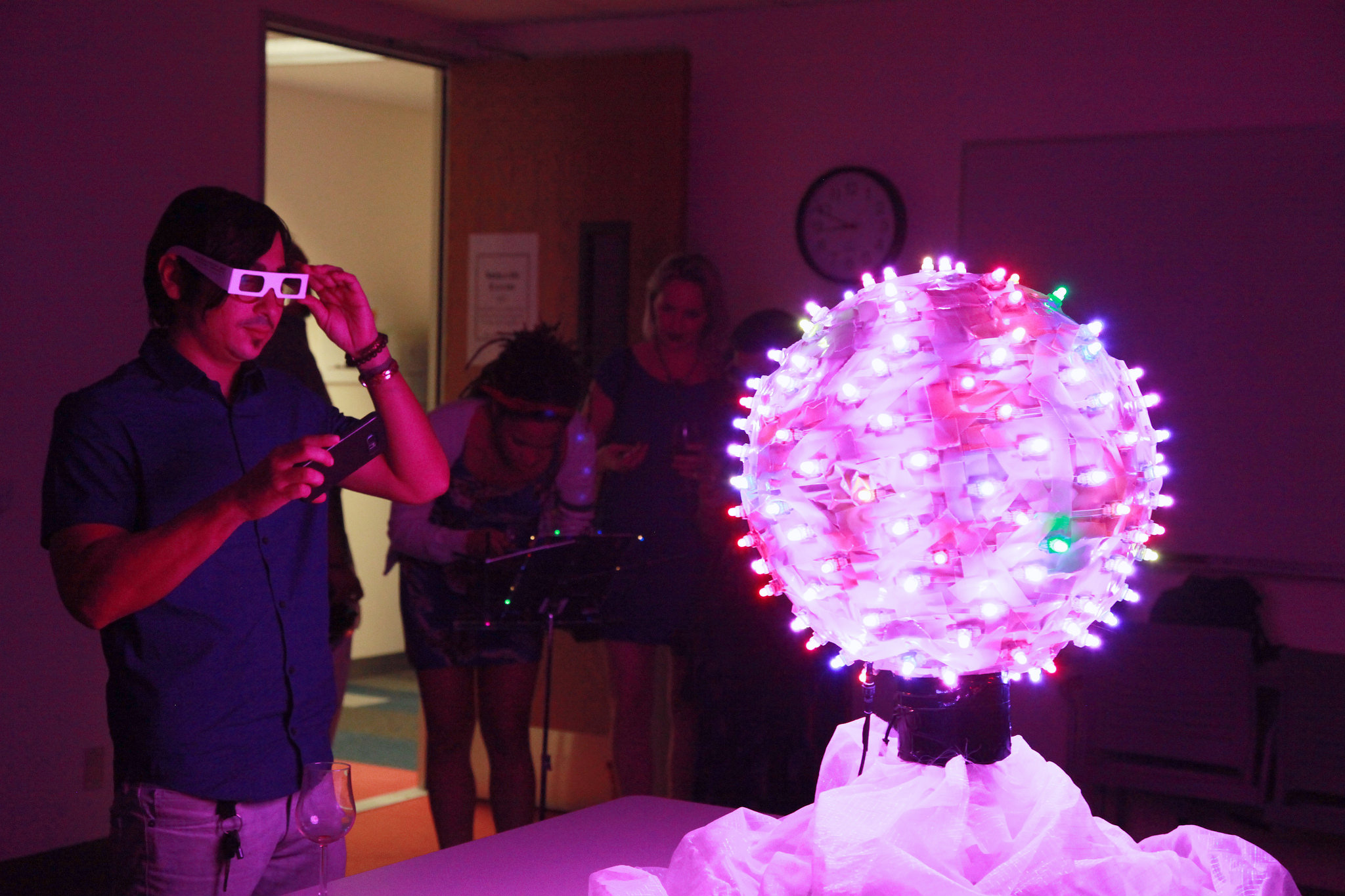 Man looking at brightly lit sphere with special glasses on