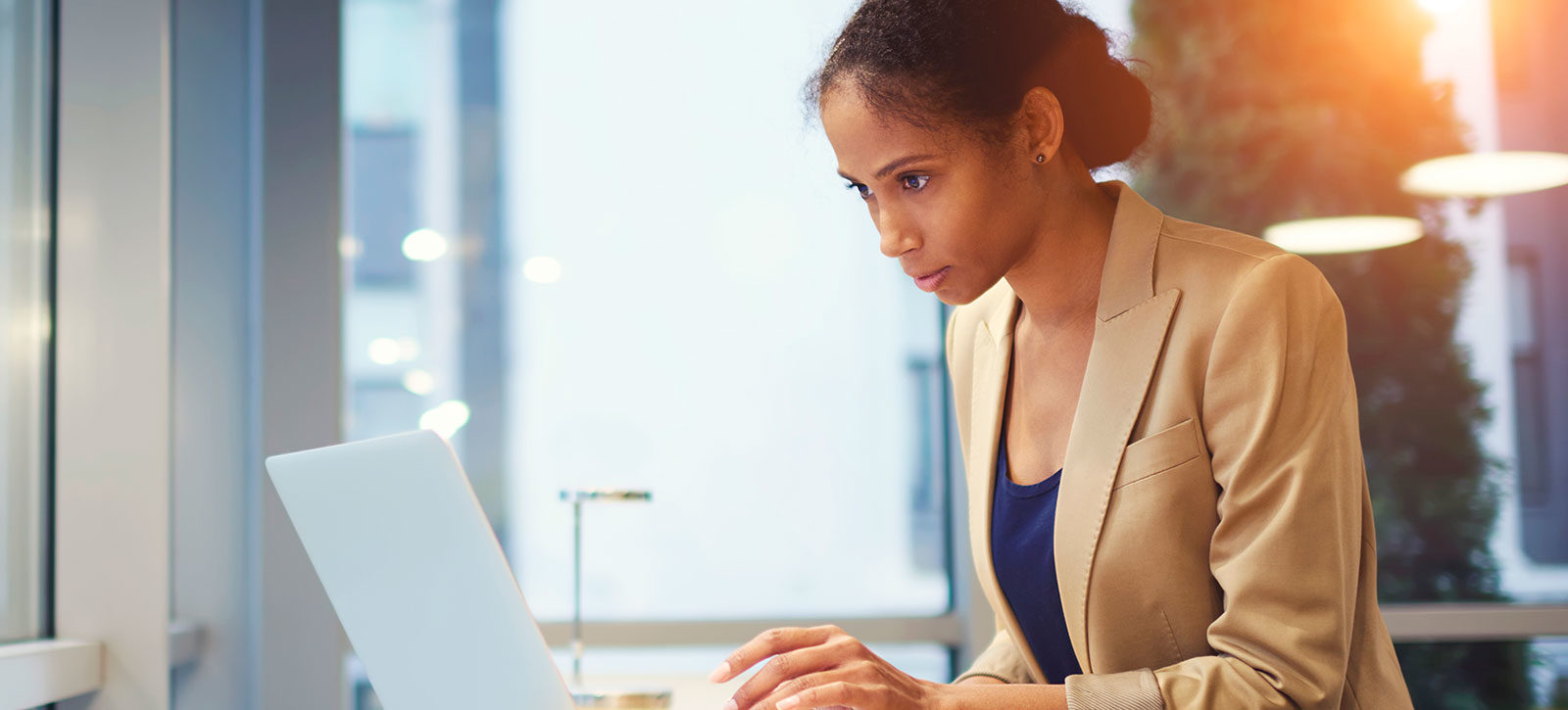 AUM_MBA_LP_Hero › Antioch University Woman in business attire working on laptop