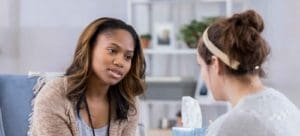 Therapy session , concerned looking counselor talking to patient
