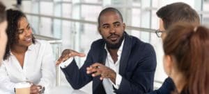 Man talking with classmates or coworkers at table