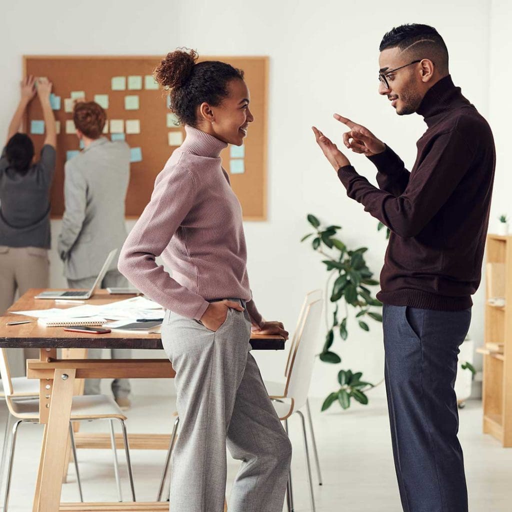 › Antioch University two people speaking directly to each other in an office environment