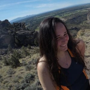 Angelina Moneir looking left and smiling with a southwestern desert in the background