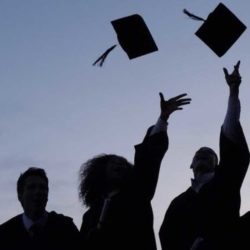Group of graduates throwing their caps in the air
