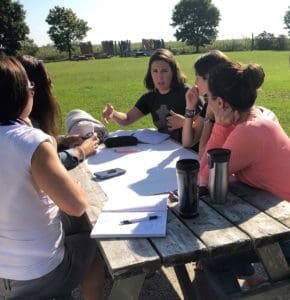 Class group outside working at picnic table