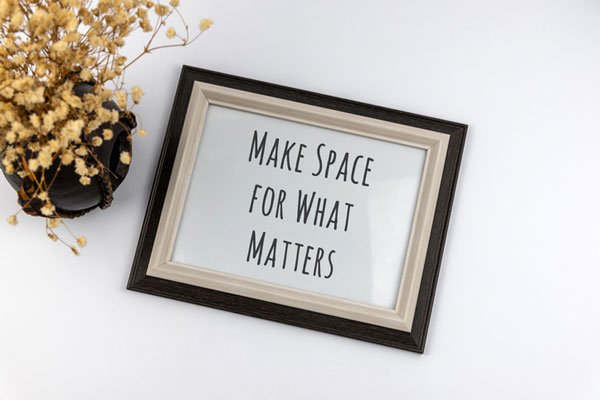 frame with the words make space for what matter next to some flowers in a vase.
