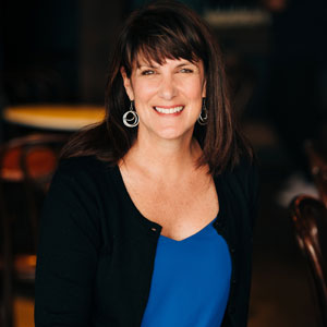 Dr. Teresa Deveaux, woman smiling, wearing a blue shirt with a black jacket