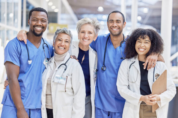 A diverse group of healthcare professionals, including doctors and nurses, standing together in unity.