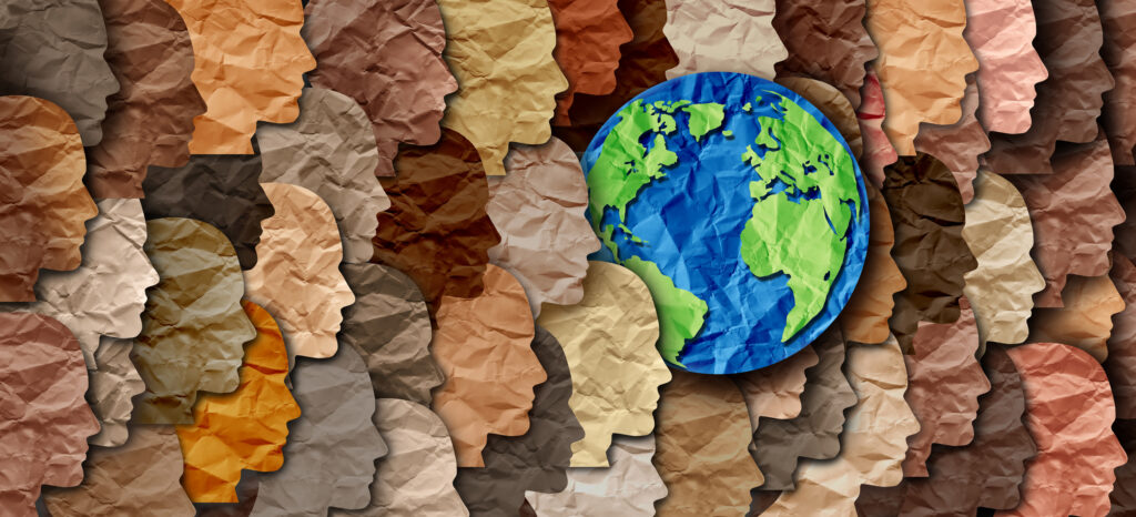 Earth globe surrounded by a crowd of multicolored paper silhouettes representing diversity around the planet