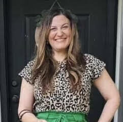Lynette-Dixon | Antioch University smile, green pants, leopard shirt, outside, door