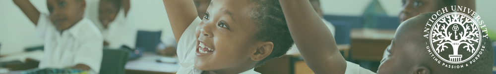 Childhood Liberal Studies Header Antioch University Children in a classroom with one child smiling and raising a hand